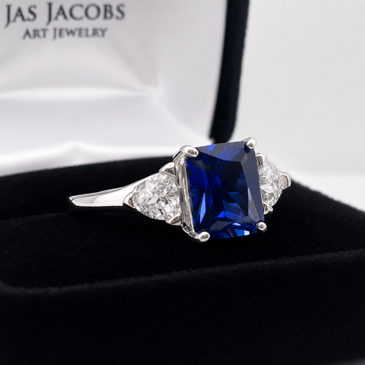 5.5ctw Emerald Cut Blue Sapphire Ring with Trillion Cut Side Stones