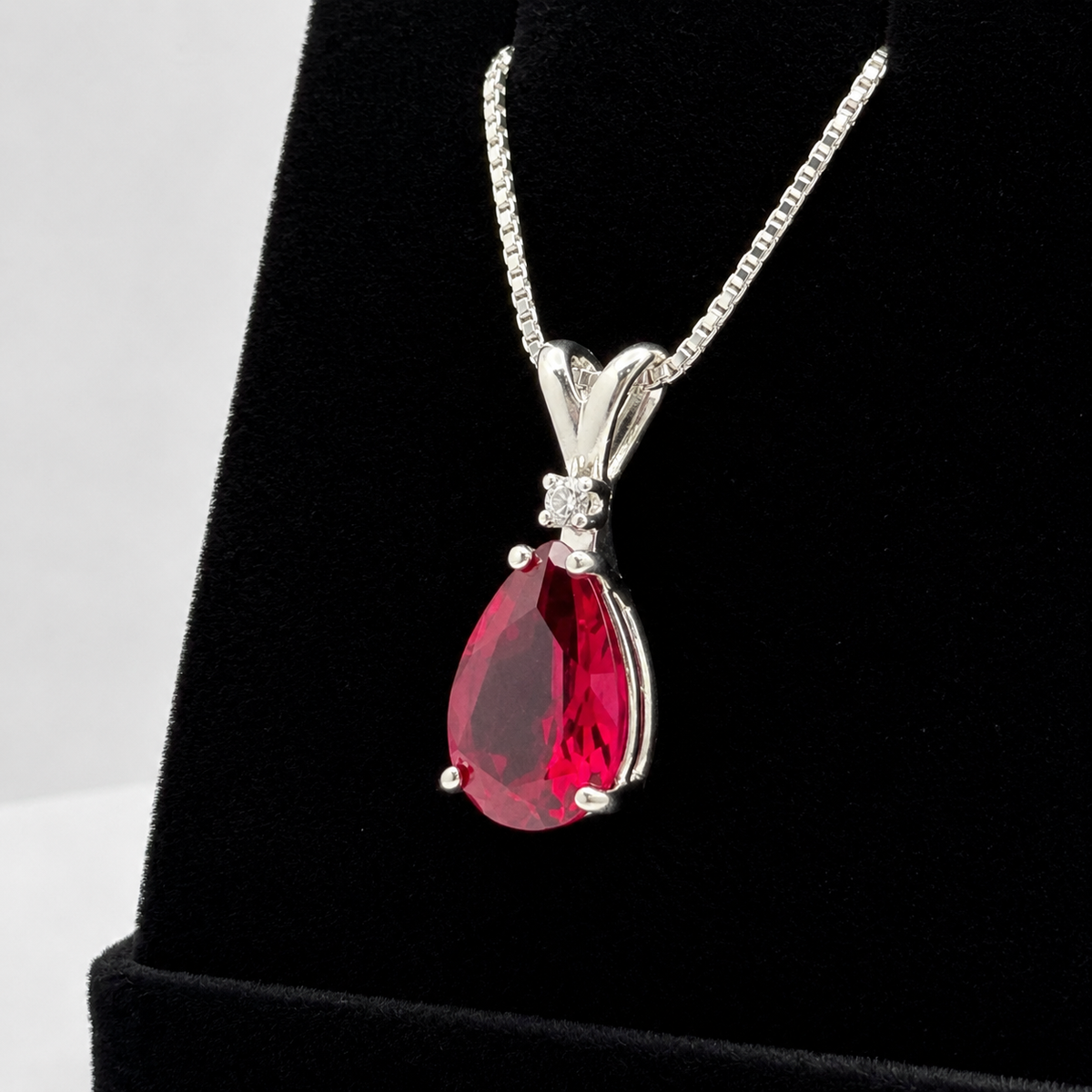 7.5ct Pear Cut Ruby Pendant Necklace with White Sapphire Accent in Sterling Silver