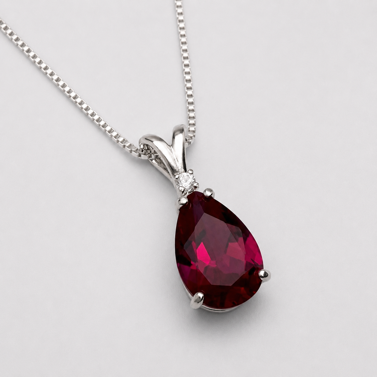 7.5ct Pear Cut Ruby Pendant Necklace with White Sapphire Accent in Sterling Silver