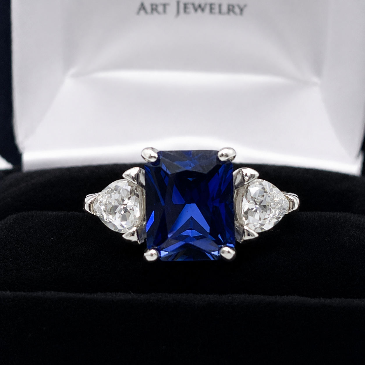 5.5ctw Emerald Cut Blue Sapphire Ring with Trillion Cut Side Stones