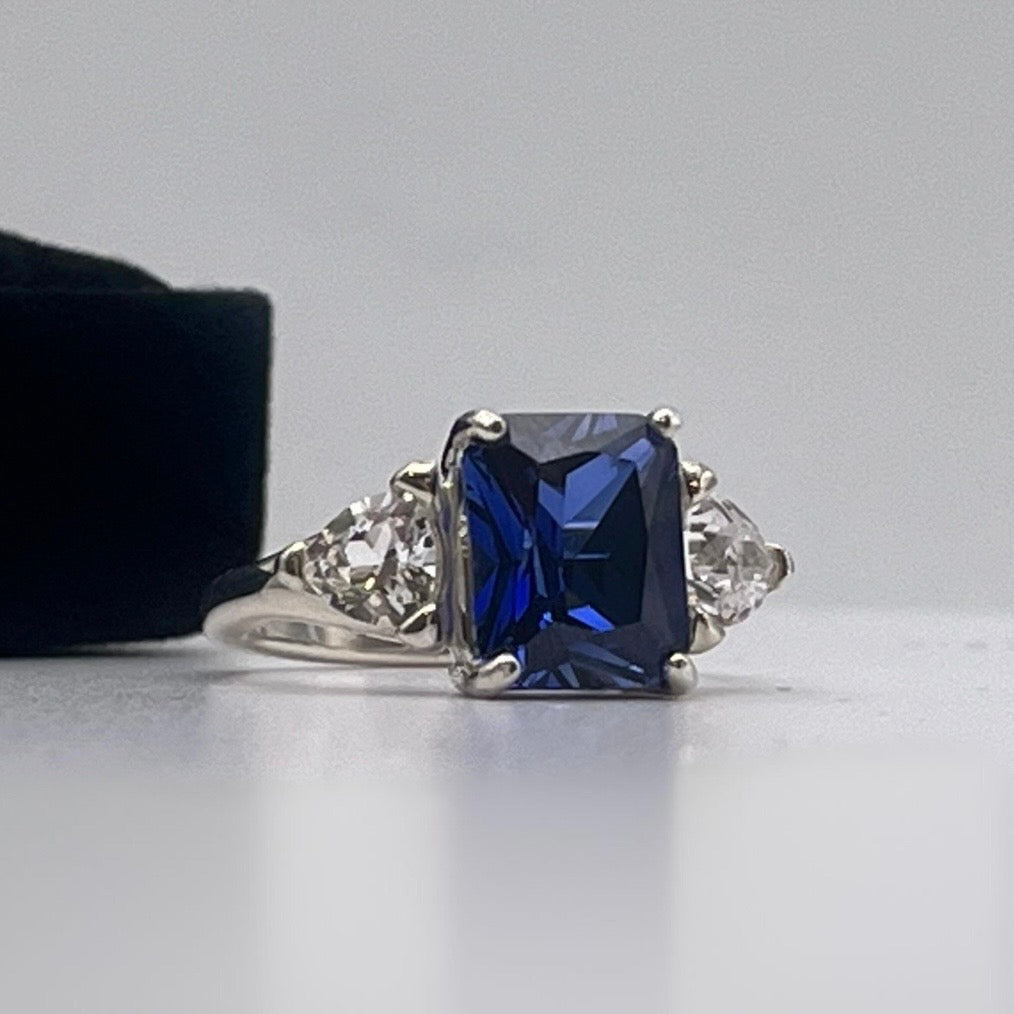 5.5ctw Emerald Cut Blue Sapphire Ring with Trillion Cut Side Stones