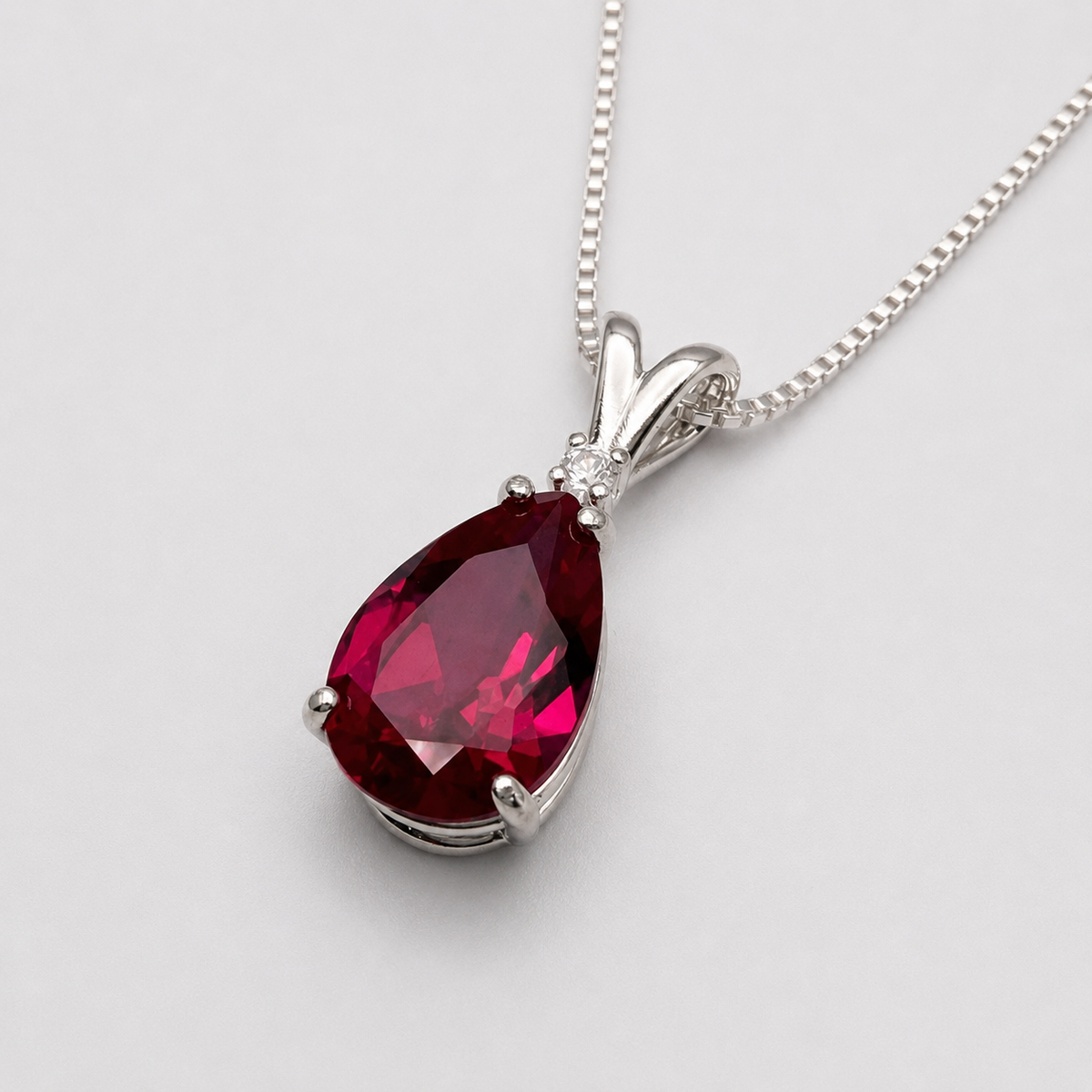 7.5ct Pear Cut Ruby Pendant Necklace with White Sapphire Accent in Sterling Silver