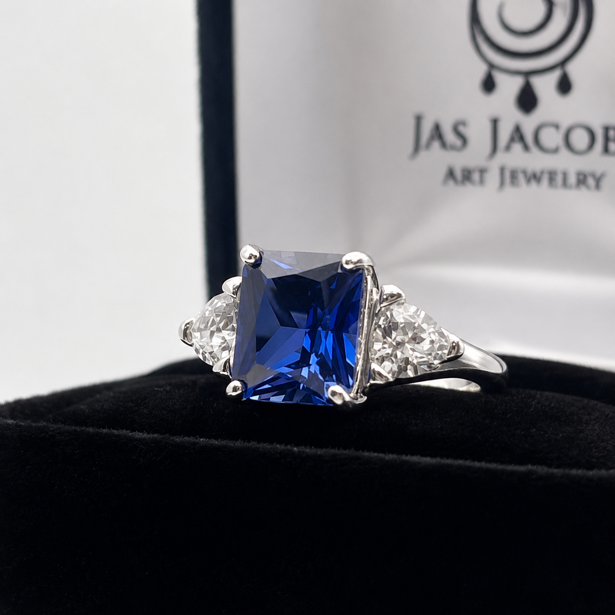 5.5ctw Emerald Cut Blue Sapphire Ring with Trillion Cut Side Stones