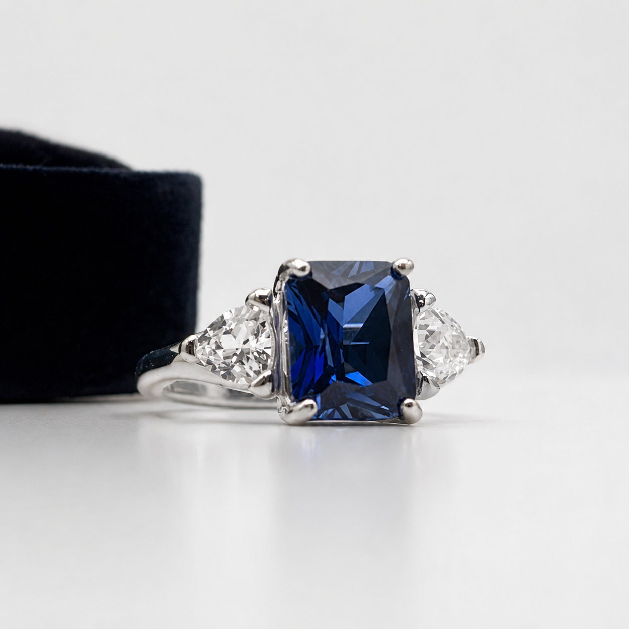 5.5ctw Emerald Cut Blue Sapphire Ring with Trillion Cut Side Stones