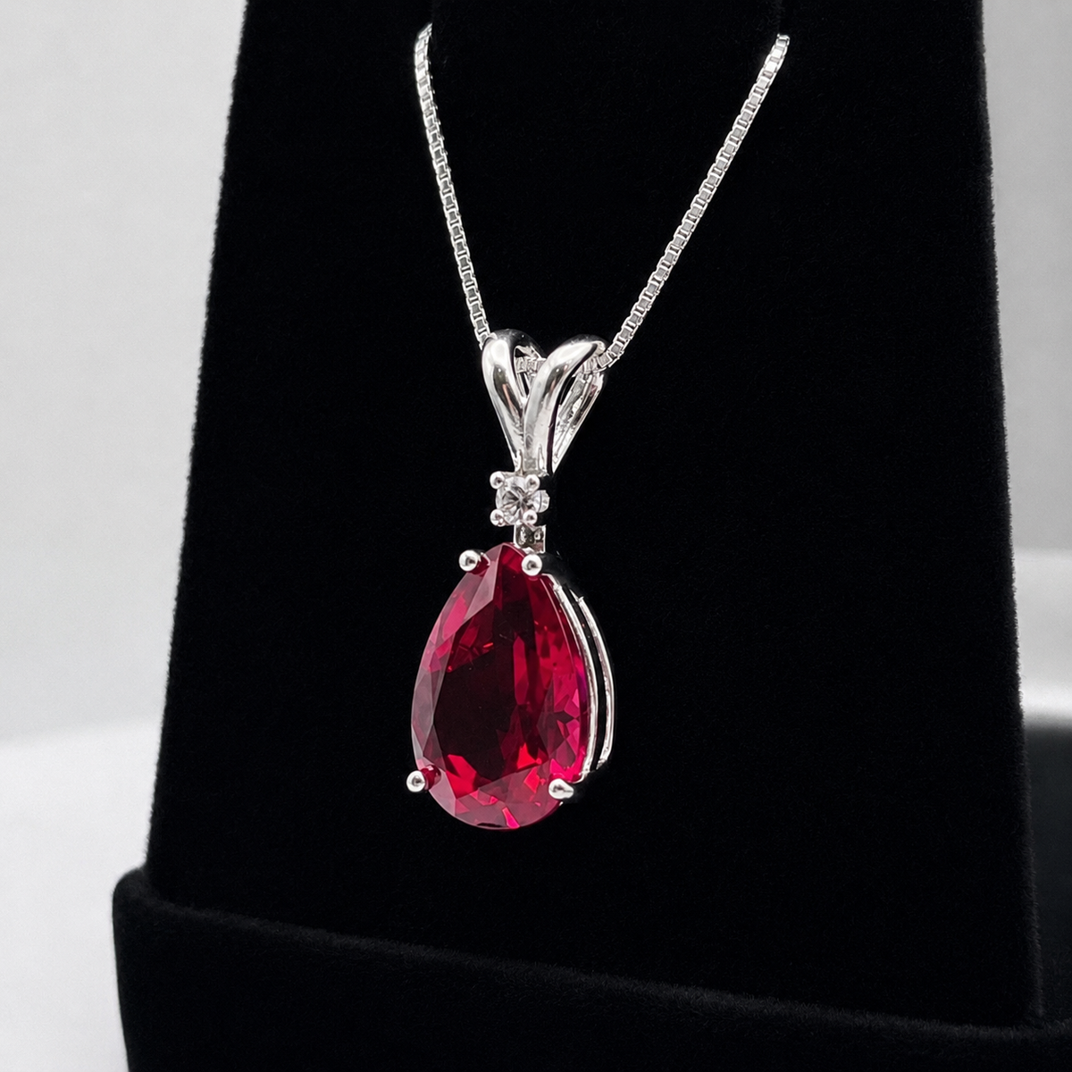 7.5ct Pear Cut Ruby Pendant Necklace with White Sapphire Accent in Sterling Silver