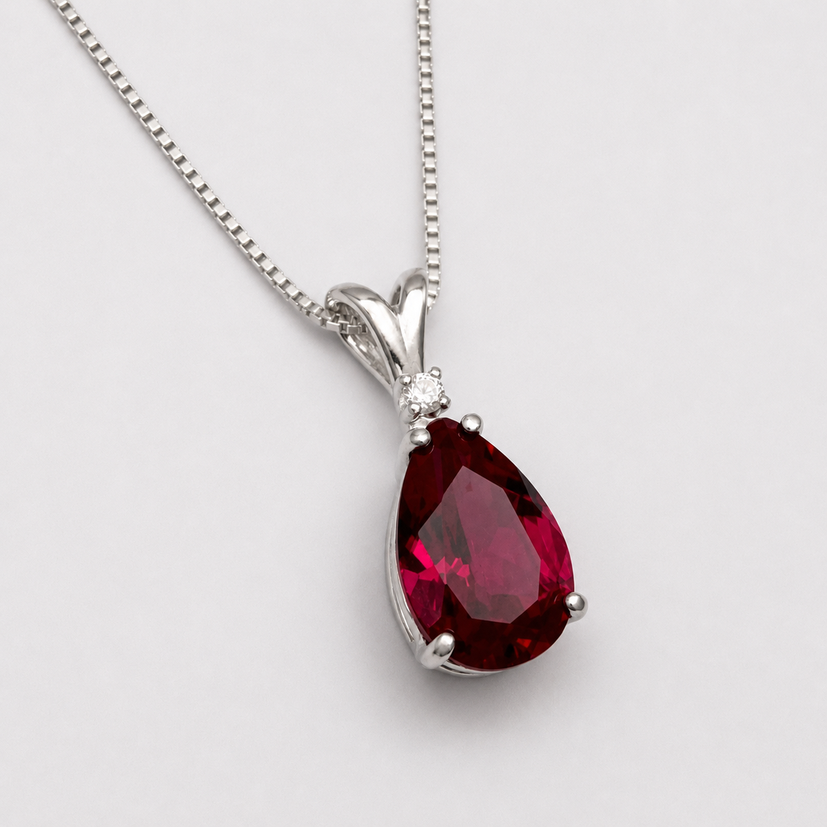 7.5ct Pear Cut Ruby Pendant Necklace with White Sapphire Accent in Sterling Silver