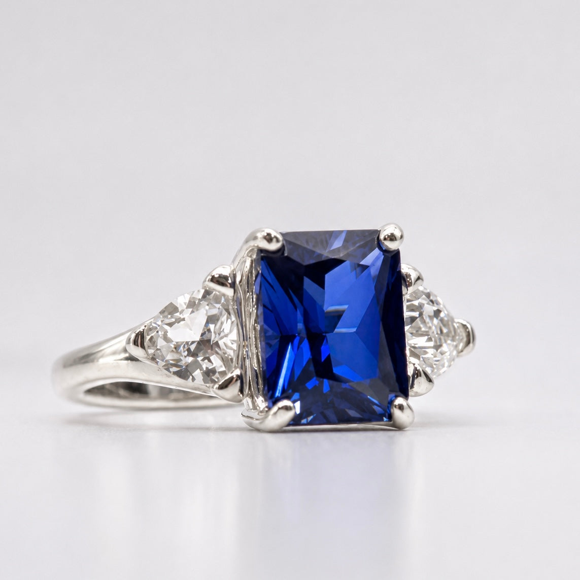 5.5ctw Emerald Cut Blue Sapphire Ring with Trillion Cut Side Stones
