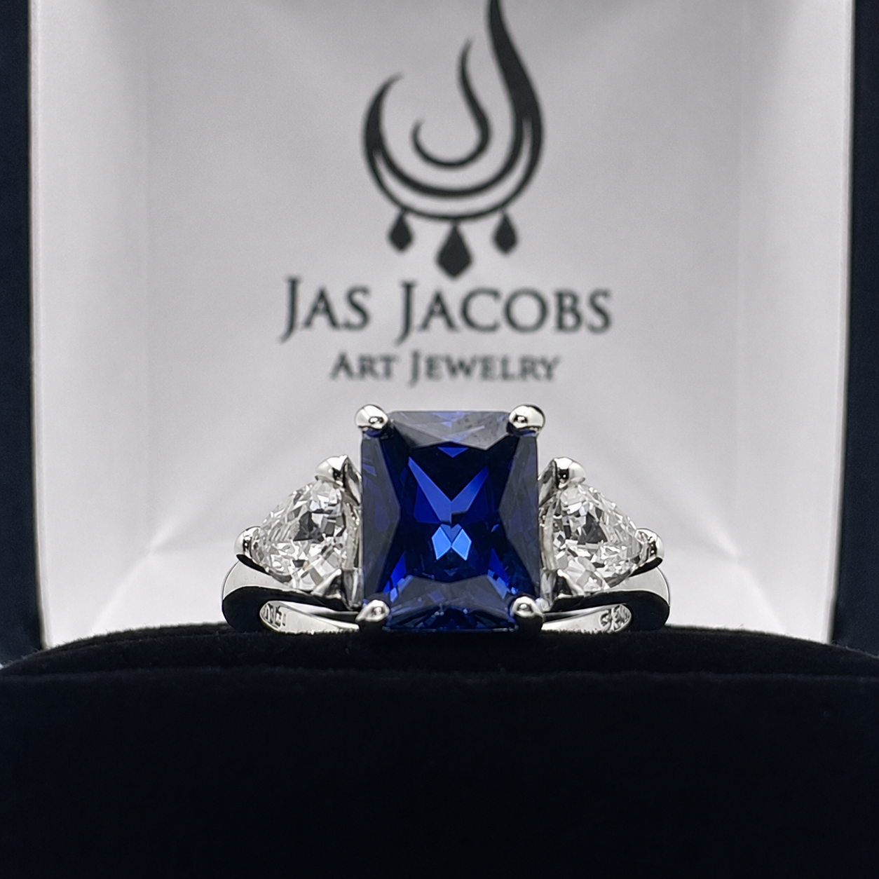 5.5ctw Emerald Cut Blue Sapphire Ring with Trillion Cut Side Stones