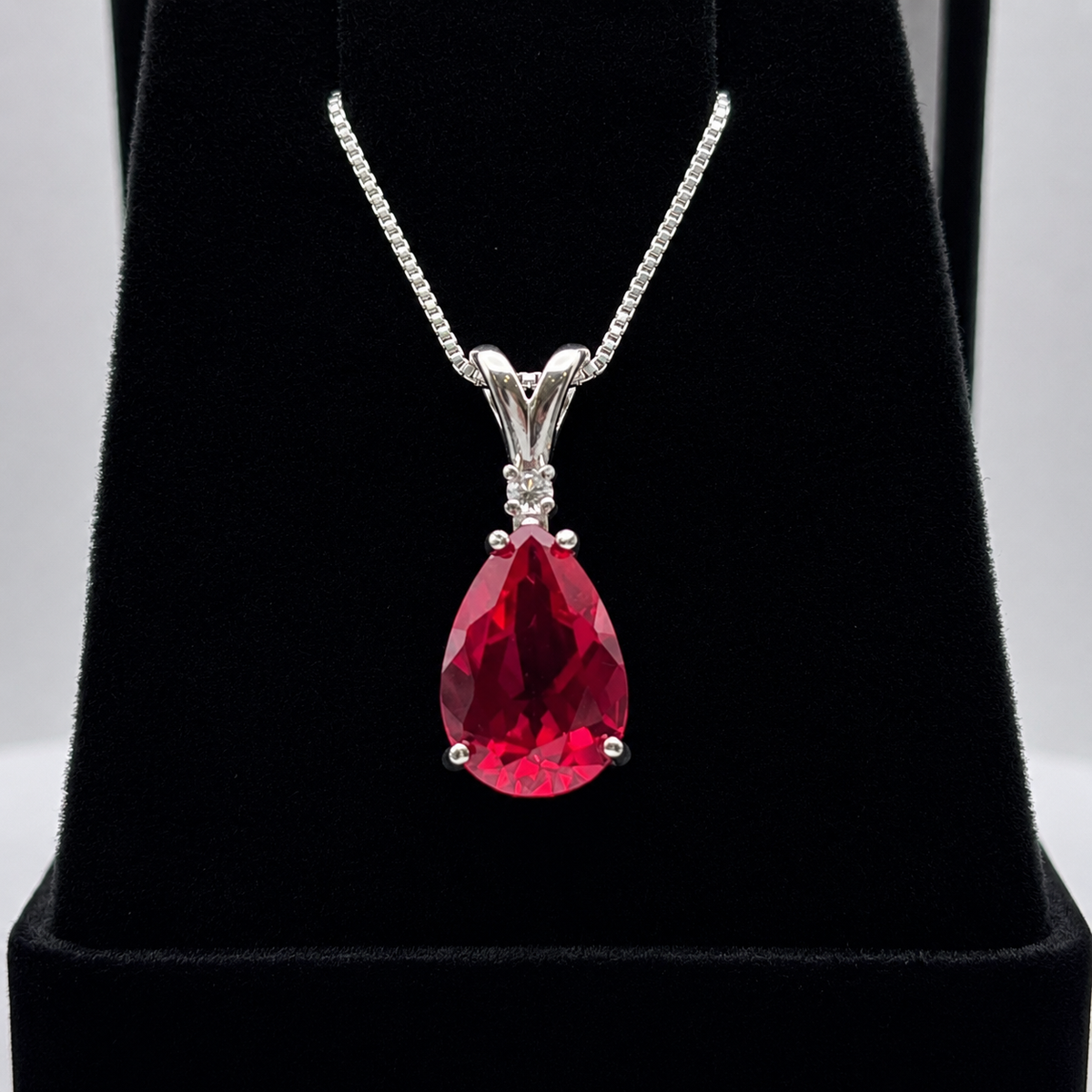 7.5ct Pear Cut Ruby Pendant Necklace with White Sapphire Accent in Sterling Silver